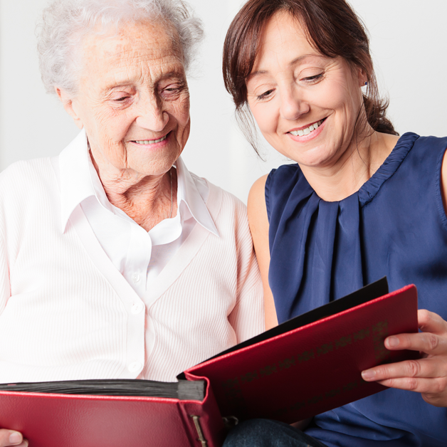 Mother and daughter look at a photo album together. 