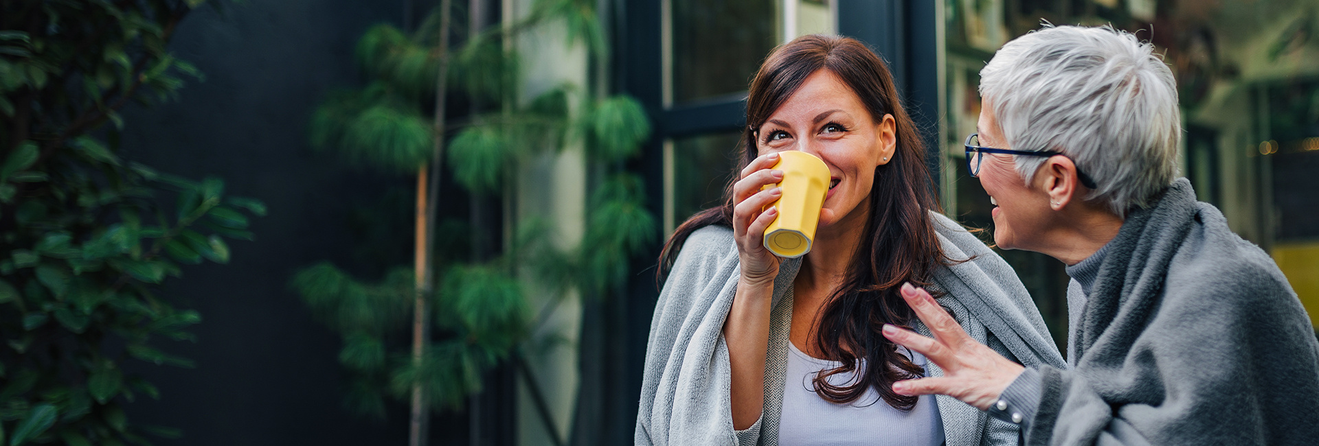 Mother and daughter share a cup of coffee. 