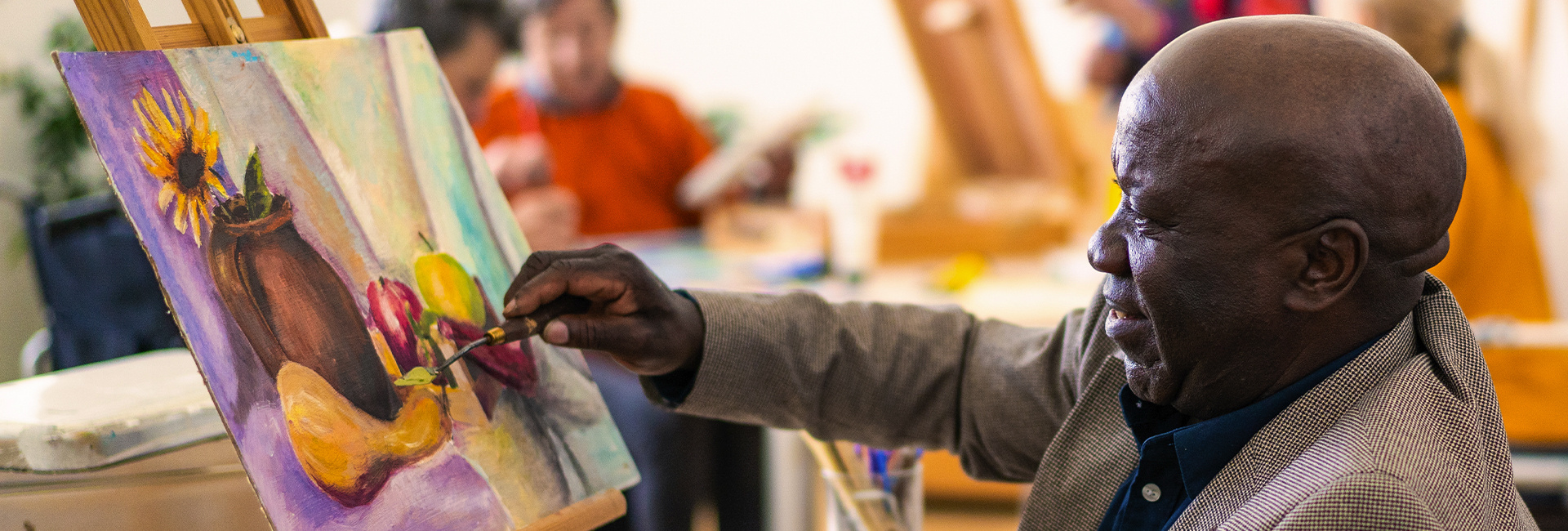 Older man enjoying an art class. 