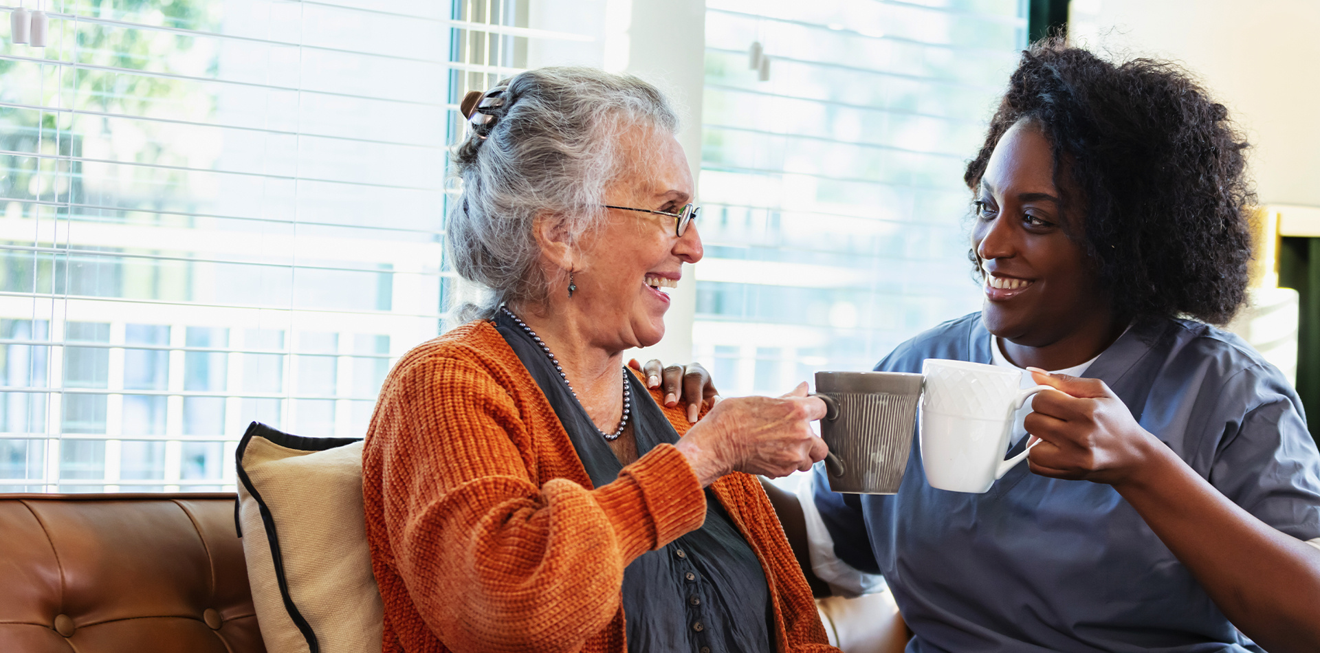 Aid shares a cup of coffee with a resident at Ebenezer Senior Living. 