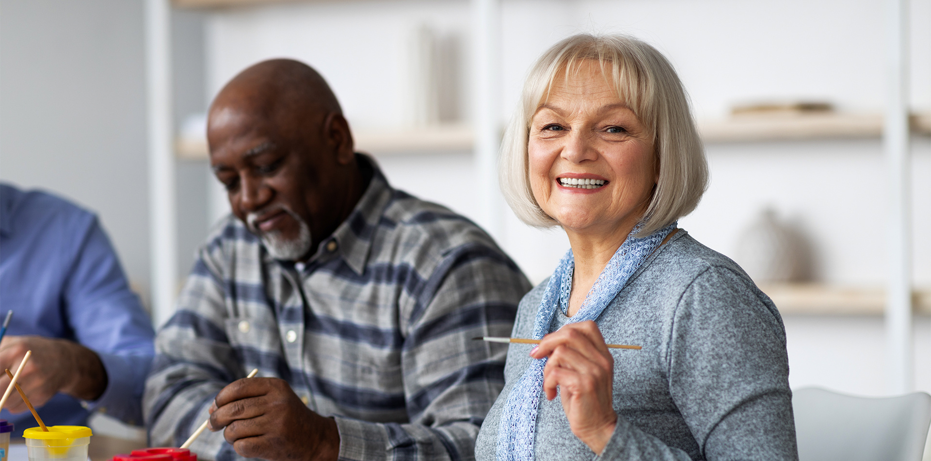 Older woman enjoying a painting class. 