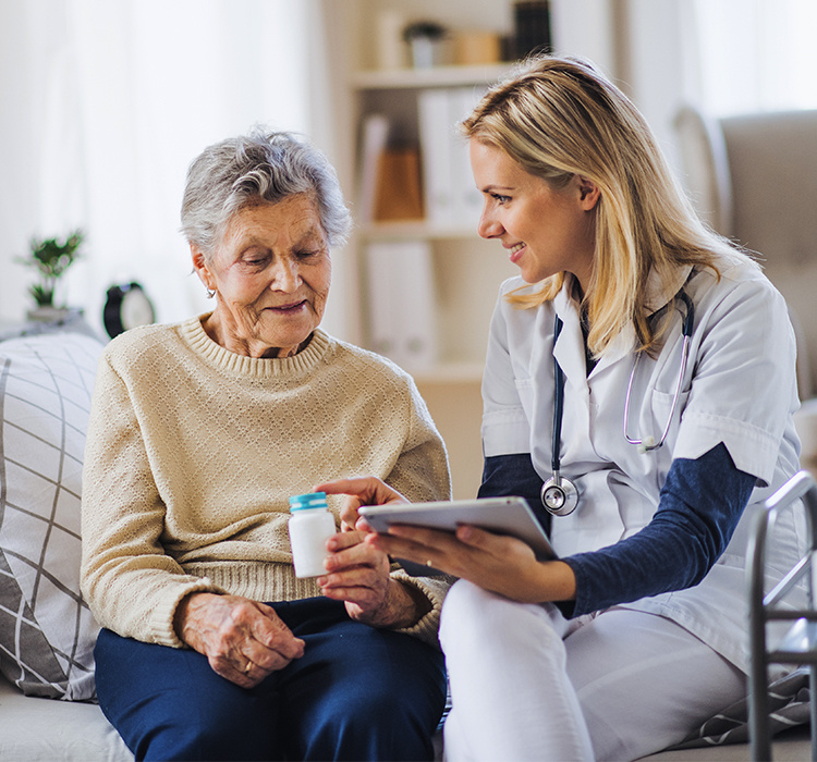 Aid helps an older woman with her medication. 