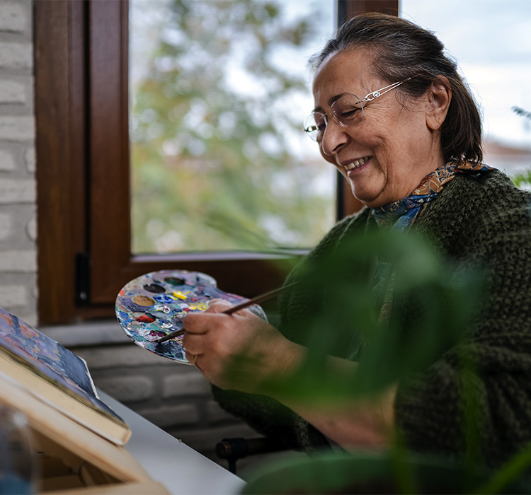 Older woman in a painting class. 