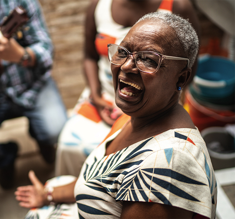 Woman shares a light-hearted moment with friends at Ebenezer Senior Living. 