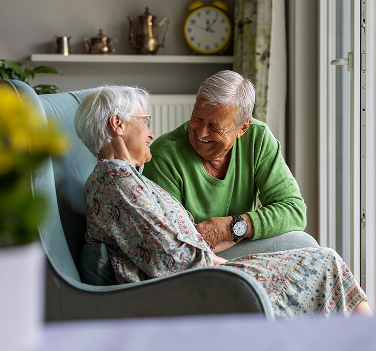 An older couple enjoy a conversation in their apartment. 
