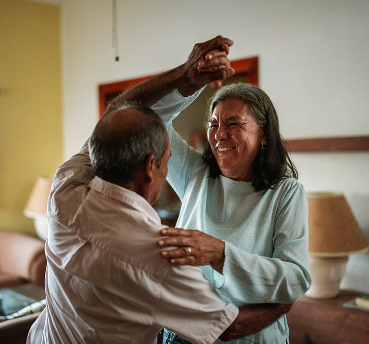Couple dancing in their living room. 