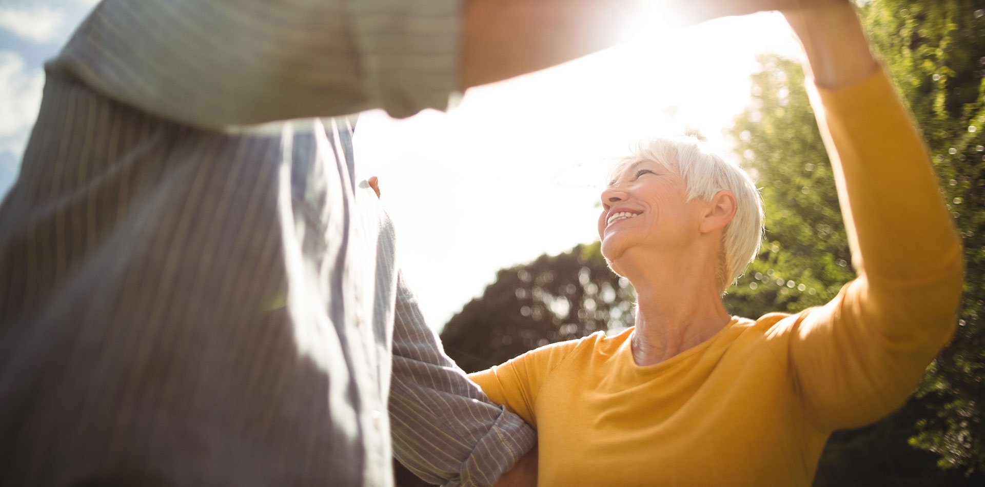 Older woman enjoys a dance with her spouse. 