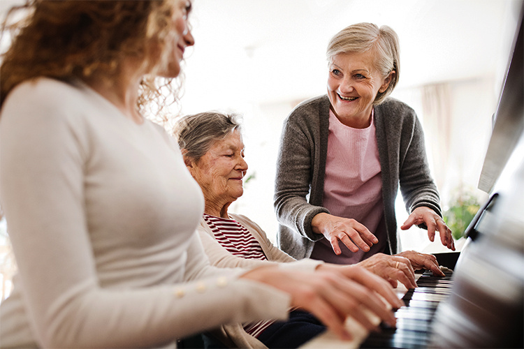Volunteer playing piano for seniors. 